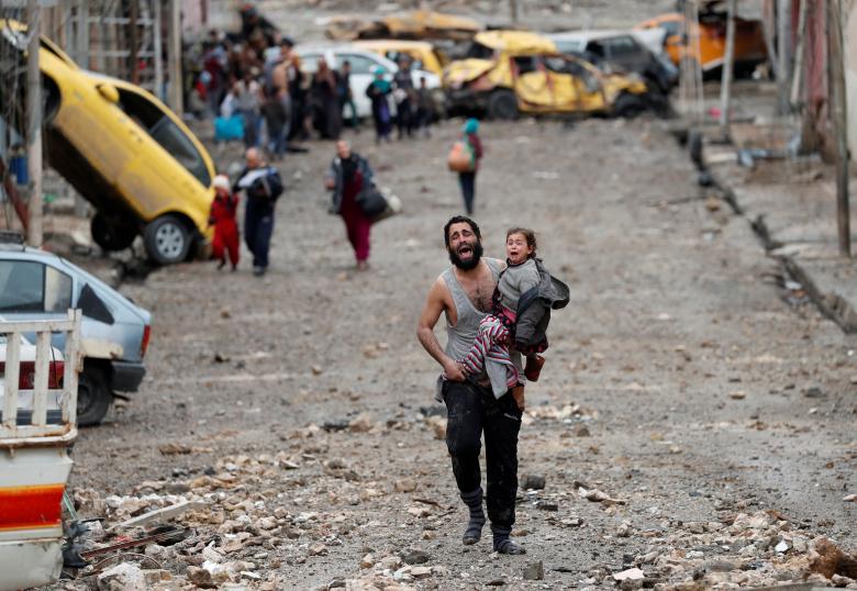 Un hombre llorando con su hija en brazos y las escalofriantes fotos de la batalla por Mosul [FOTOS]