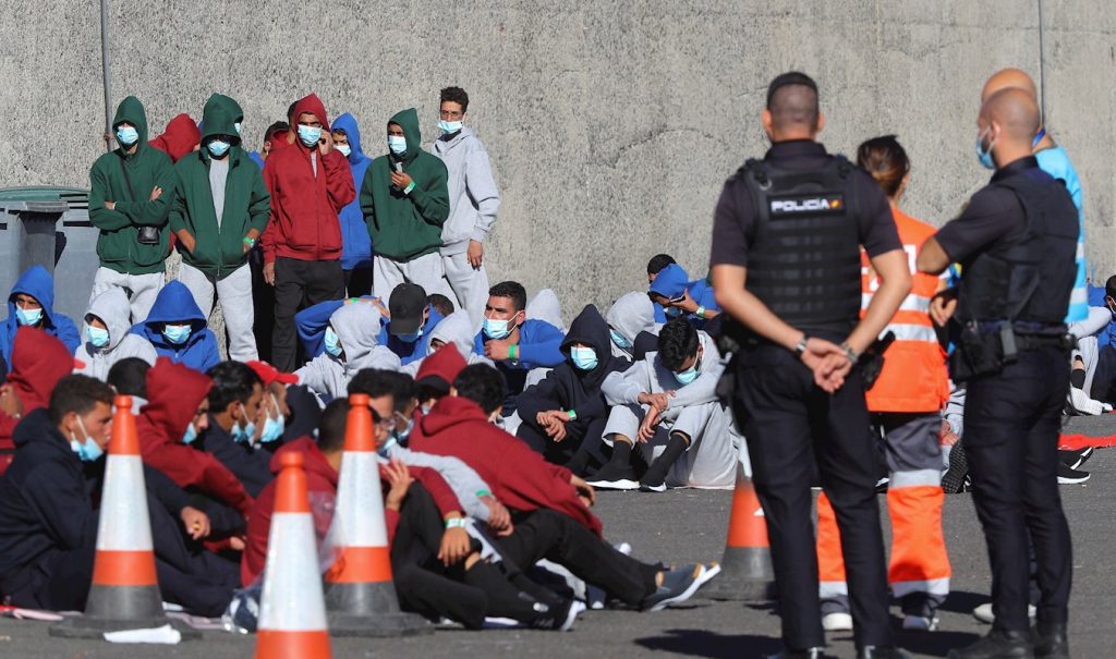 Varios inmigrantes descansan en el muelle de Arguineguín tras ser rescatados por Salvamento Marítimo, el pasado domingo, en Gran Canaria. — Elvira Urquijo A. / EFE
