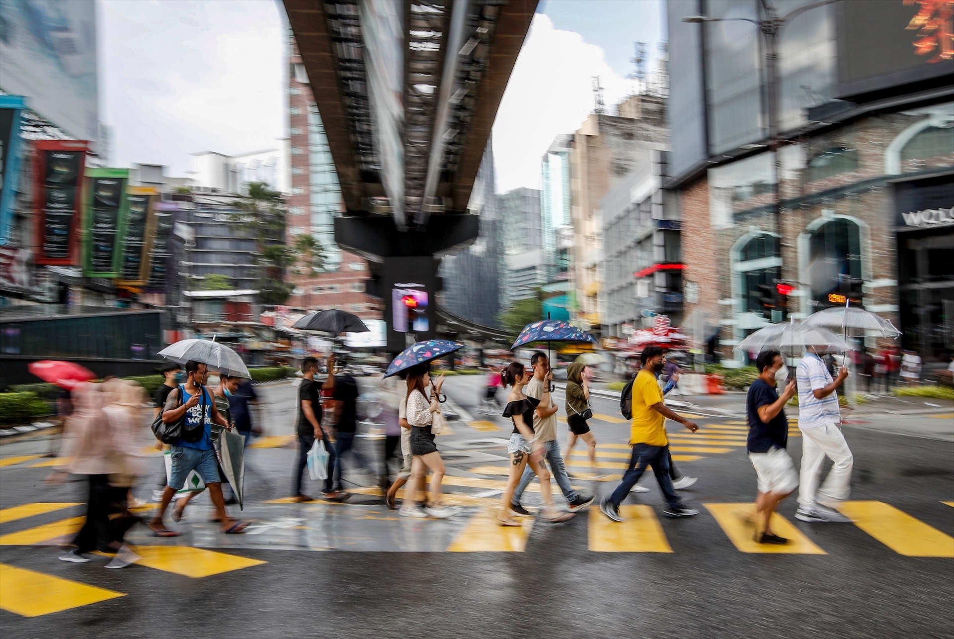 Los peatones con paraguas cruzan una intersección durante la lluvia cerca de los distritos comerciales de Kuala Lumpur (Malasia), a 15 de octubre de 2022. Foto: Wong Fok Loy / SOPA Images via ZUM / DPA