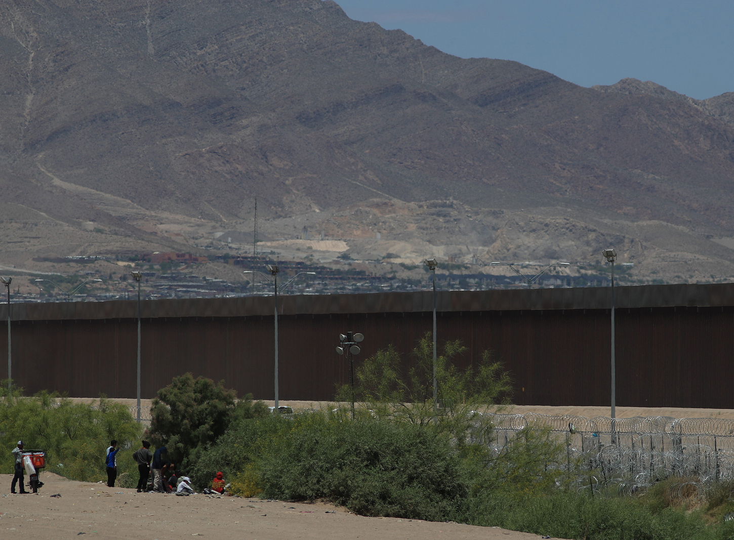 Policías de la Guardia Nacional de Texas impide a personas migrantes abandonar el territorio mexicano desde el muro que divide a México con Estados Unidos, en Ciudad Juárez (México).-EFE/Luis Torres