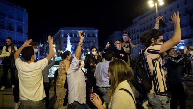 Varios jóvenes saltan y bailan en la Puerta del Sol.EFE