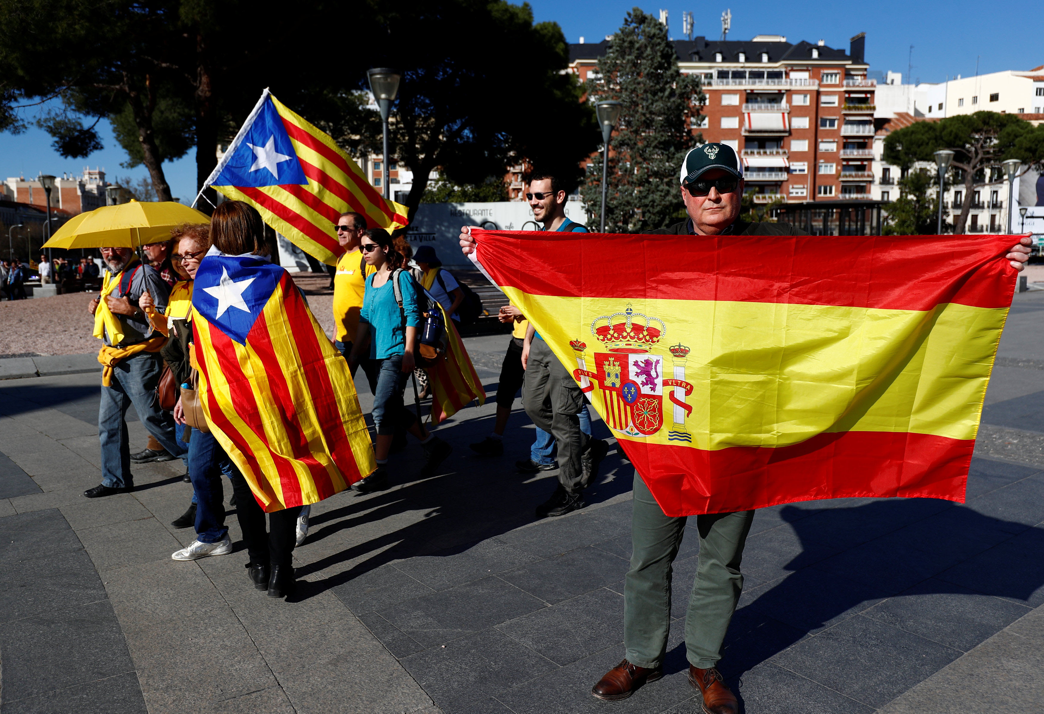 Un hombre sostiene una bandera española junto a personas con banderas estelades, que participaban en la marcha por el derecho a decidir de este fin de semana en Madrid. REUTERS / Juan Medina