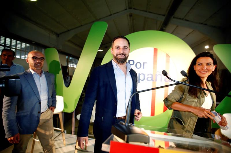 El líder de Vox, Santiago Abascal (c), junto a los candidatos de Vox al Parlamento Europeo, Jorge Buxadé (i); y a la Comunidad de Madrid, Rocío Monasterio (d), antes de intervenir en el acto previo al inicio de campaña de la formación, en Paracuellos del Jarama. EFE/Javier López