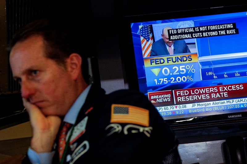 La noticia de la rebaja de los tipos de interés en EEUU en un monitor de televisión en el patio de negociación de la Bolsa de Nueva York.. REUTERS/Brendan McDermid