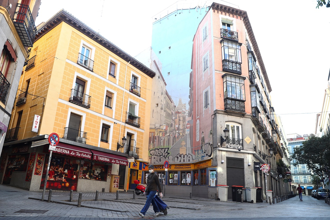 Una mujer con mascarilla y un carrito de la compra, por las calles del centro de Madrid. REUTERS/Sergio Perez