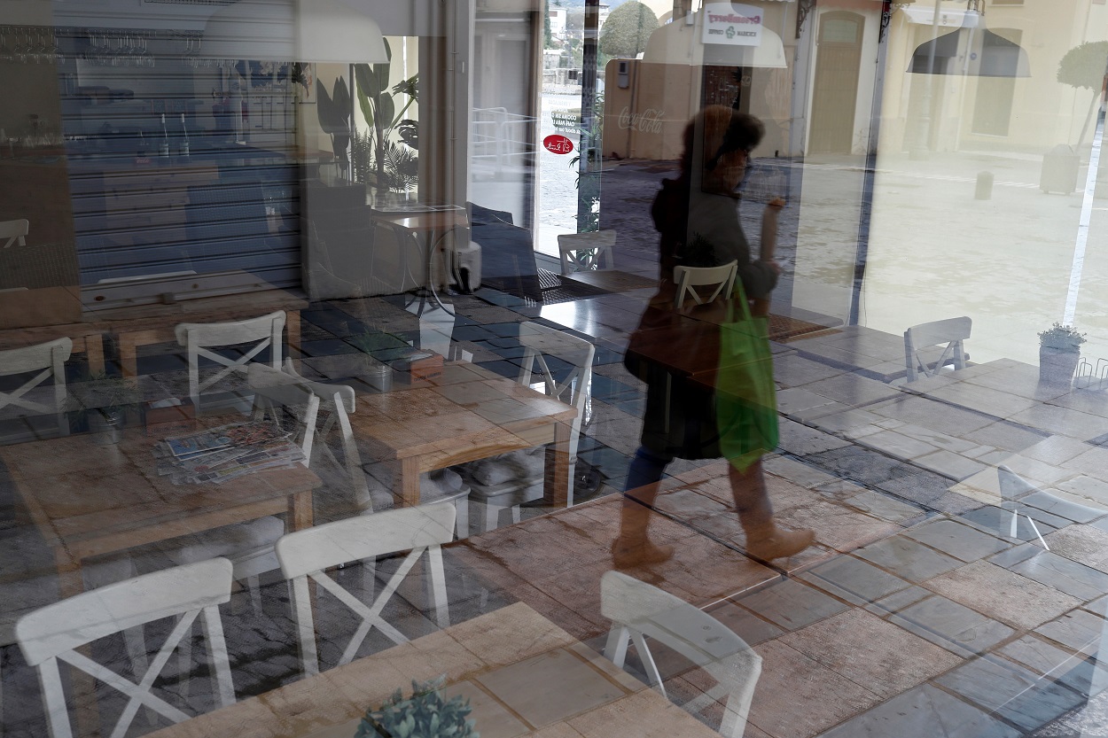 El reflejo de una mujer en el ventanal de un restaurante cerrado, en la localidad malagueña de Ronda. REUTERS/Jon Nazca