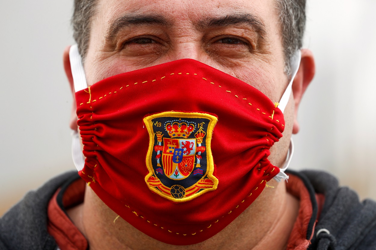 Un hombre, con una mascarilla casera con el escudo de la selección española de fútbol. REUTERS/Jon Nazca