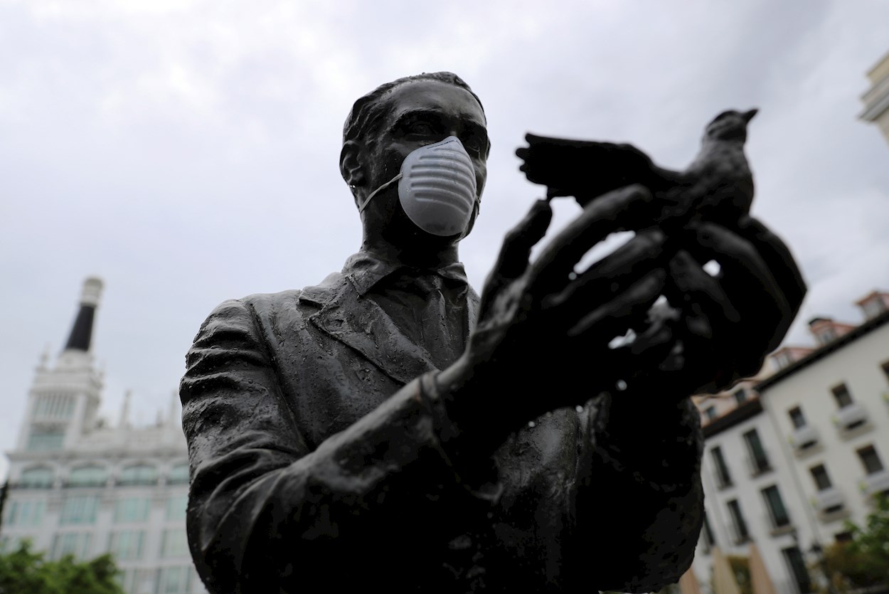 La estatua de Federico García Lorca, en la madrileña plaza de Santa Ana, ataviada con una mascarilla facial durante una nueva jornada de confinamiento por la crisis del coronavirus. EFE/Rodrigo Jiménez