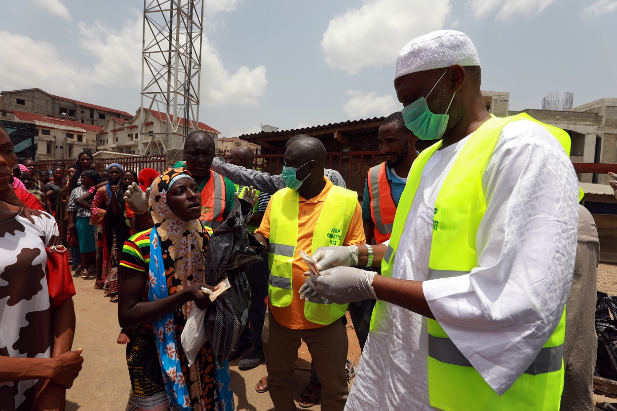 Una cola de personas para recibir ayuda alimentaria durante las medidas confinamiento por la pandemia del coronavirus, en Abuja, Nigeria. REUTERS / Afollabi Sotunde