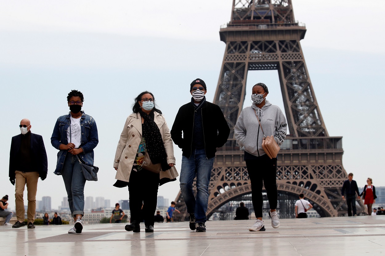 Personas con mascarilla pasean cerca de la Torre Eiffel, en París. . REUTERS/Gonzalo Fuentes