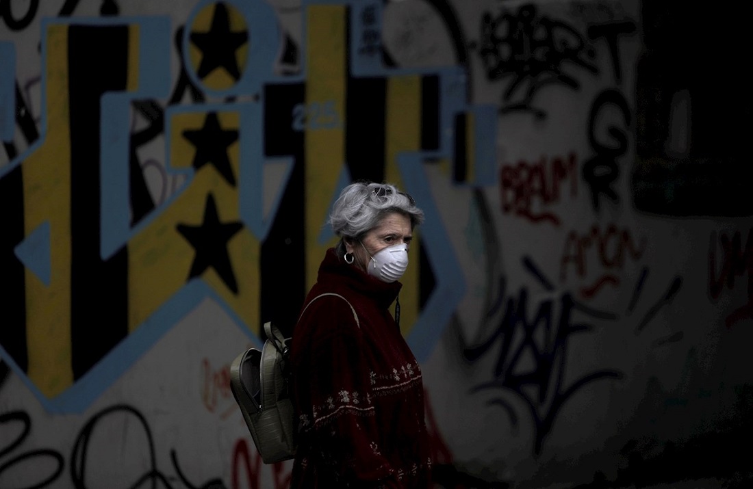 Una mujer con mascarilla pasea por una calle del centro de A Coruña. EFE