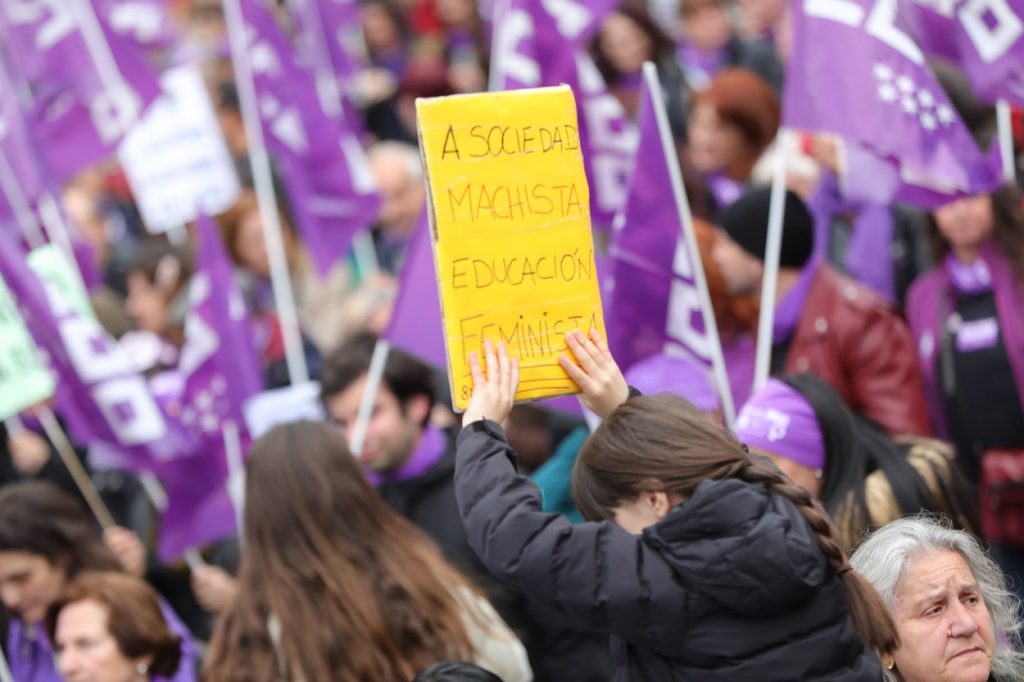 Una joven con un cartel en el que pone "A sociedad machista educación feminista" en la manifestación del 8M en Madrid. E.P./Jesús Hellín