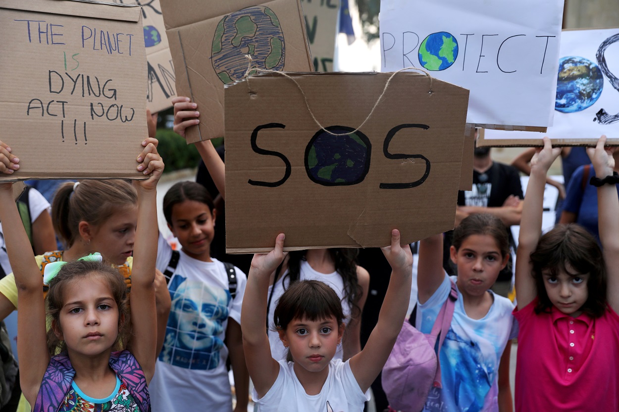 Varios niños sostienen pancartas en una manifestación contra el calentamiento global, en Nicosia (Chipre). REUTERS/Yiannis Kourtoglou