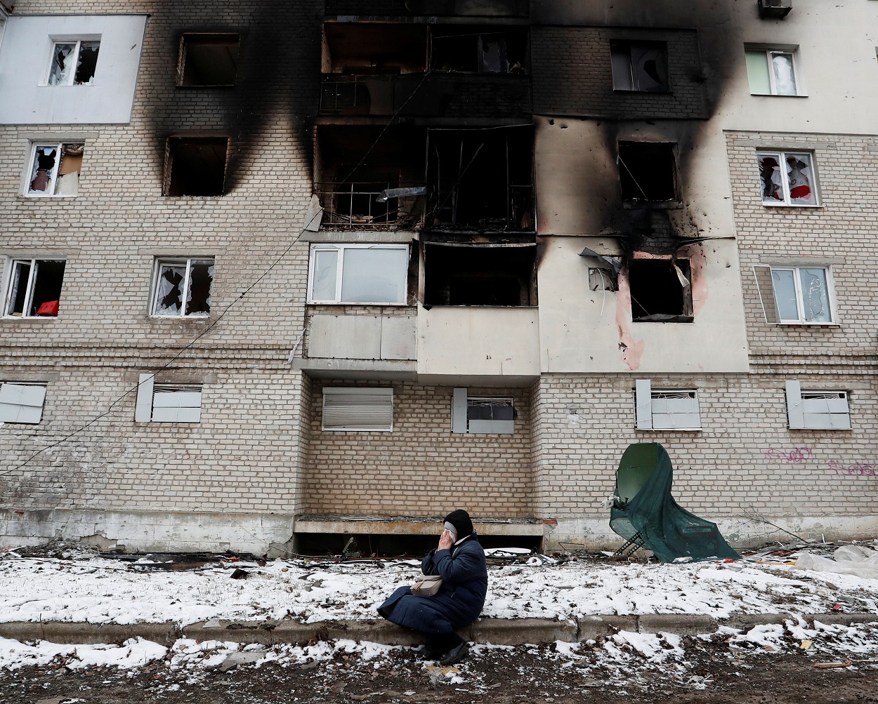 Una mujer, frente a un edificio gravemente dañado por los bombardeos rusos, en localidad de Volnovaja, en la región de Donetsk (Ucrania). REUTERS/Alexander Ermochenko