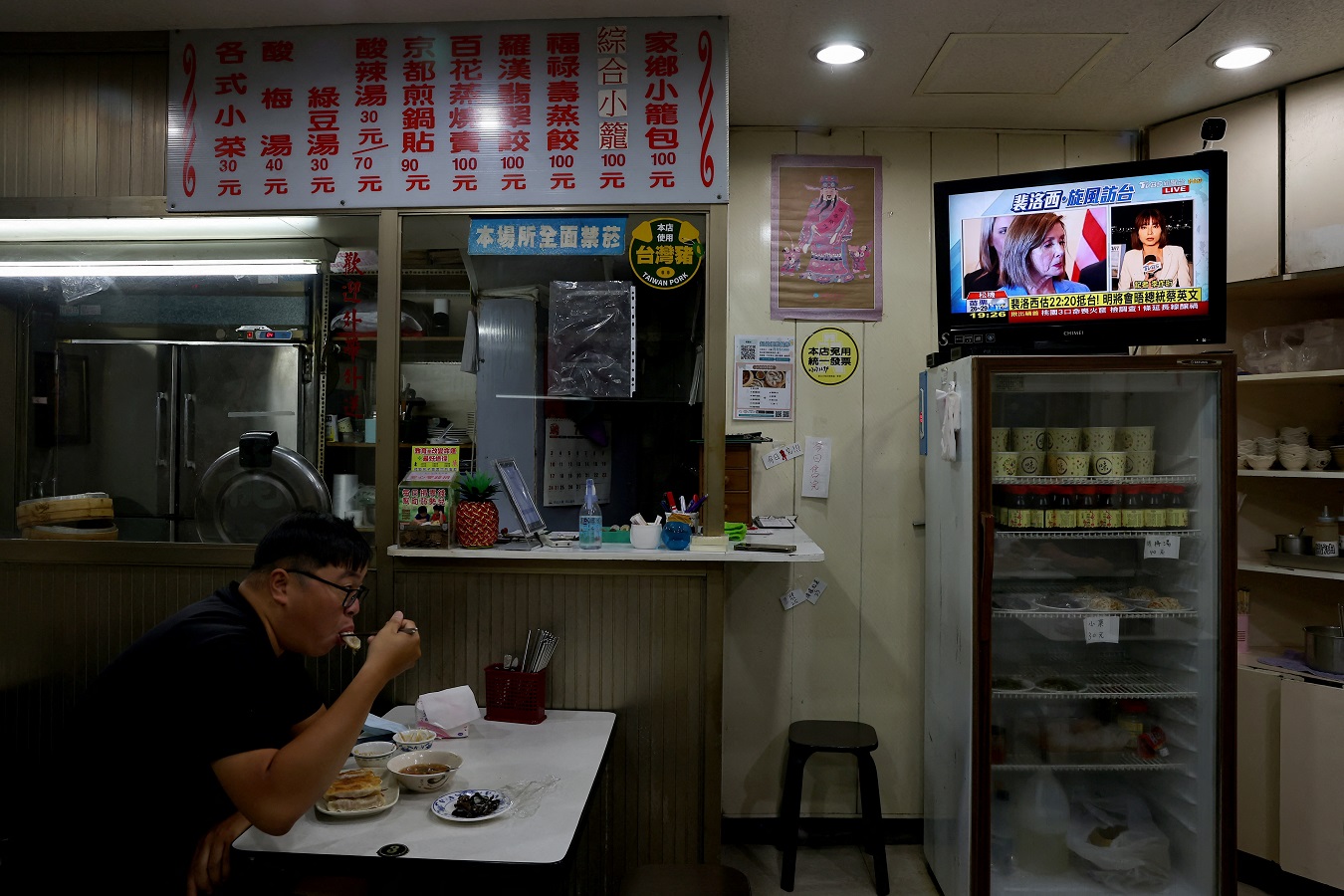 Un hombre almuerza en un restaurante de Taipei, la capital de Taiwan, mientras en la televisión informan sobre la visita de la presidenta de la Cámara de Representantes de EEUU, Nancy Pelosi. REUTERS/Ann Wang