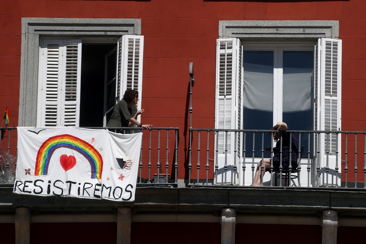 Dos vecinas hablan en sus balcones durante la cuarentena por la pandemia del coronavirus en Madrid. / SUSANA VERA (REUTERS)