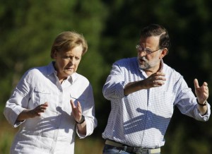 German Chancellor Merkel and Spanish Prime Minister Rajoy  talk as they walk along a stretch of the way of St. James near Santiago de Compostela, northwestern Spain