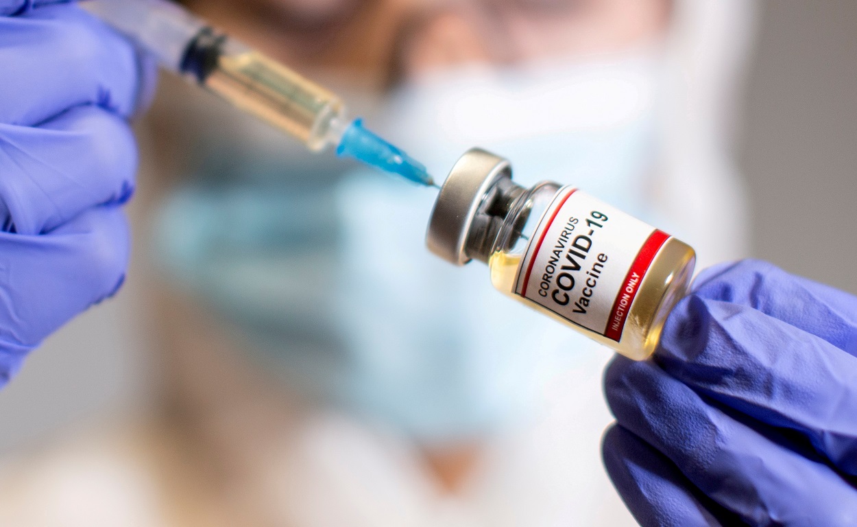 Una mujer sostiene una botellita con una etiqueta que dice 'vacuna del coronavius covid-19'. REUTERS/ILustracion/Dado Ruvic