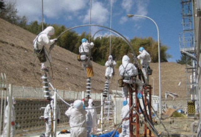 Trabajadores con equipo protector restableciendo el suministro a la unidad 3. Foto: TEPCO. (Clic para ampliar)