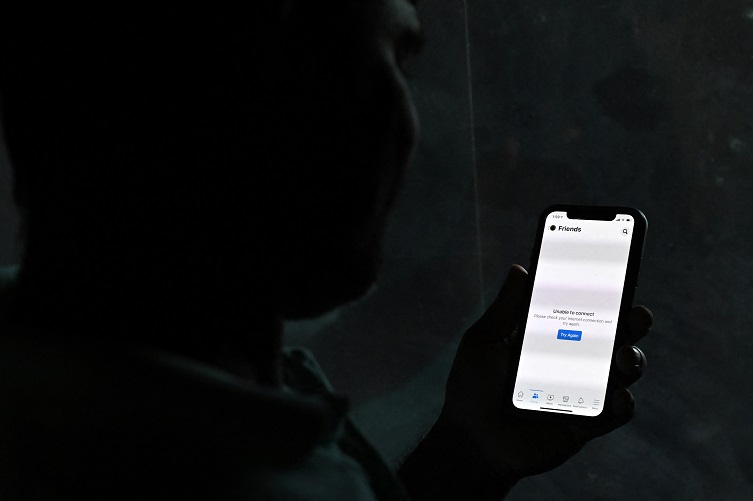 Una persona utiliza su teléfono móvil en la oscuridad.- Ishara S. Kodikara / AFP