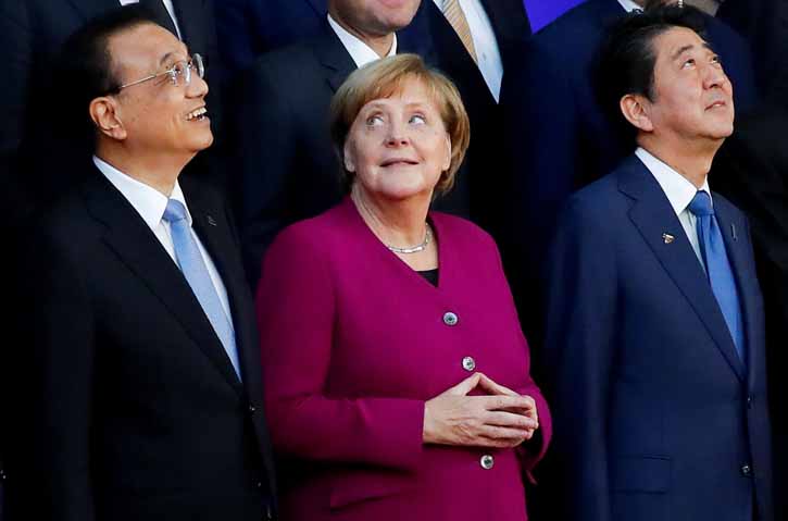 La canciller alemana Angela mwerkel, entre el primer ministro chino Li Keqiang y su homólogo japonés Shinzo Abe, en la foto de familia de la Reunión Asia-Europa, celebrada los días 18 y 19 de octubre en Bruselas. REUTERS/Yves Herman