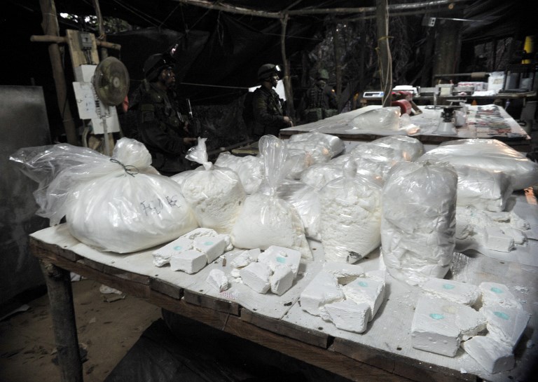 Policías colombianos colombian la droga aprehendida en un laboratorio ilegal de coaina, en la localidad de Puerto Gaitan (en el departamento de Meta), en octubre de 2011. AFP/Guillermo Legaria