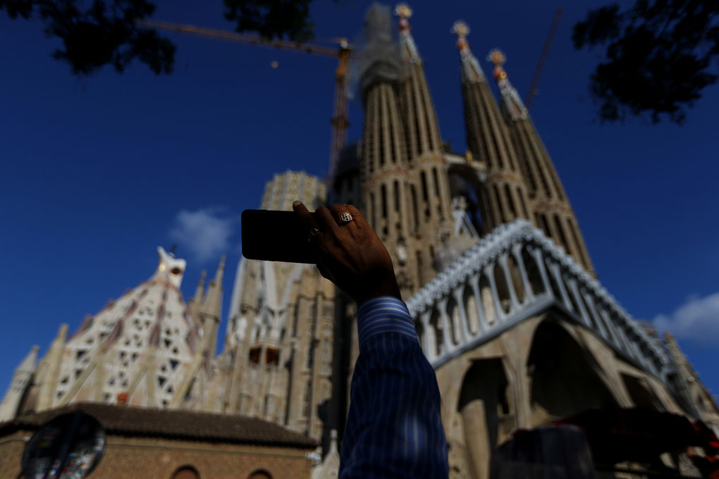 Un hombre toma una imagen con su smartphone de la Sagrada Familia, en Barcelona. REUTERS