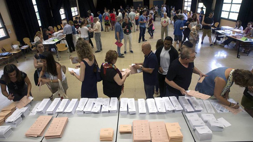 Varios ciudadanos eligen las papeletas en un colegio electoral. EFE/Quique García