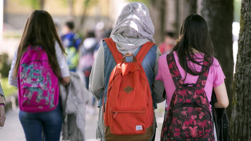 Tres escolares, una de ellas vistiendo velo, a la salida del colegio en Vitoria. EFE/David Aguilar