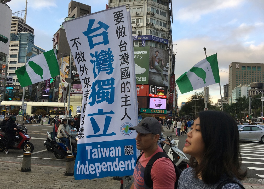 Varias personas pasan junto a una bandera en apoyo de la independencia de Taiwán, en el distrito comercial Ximending en Taipei. REUTERS / Ben Blanchard