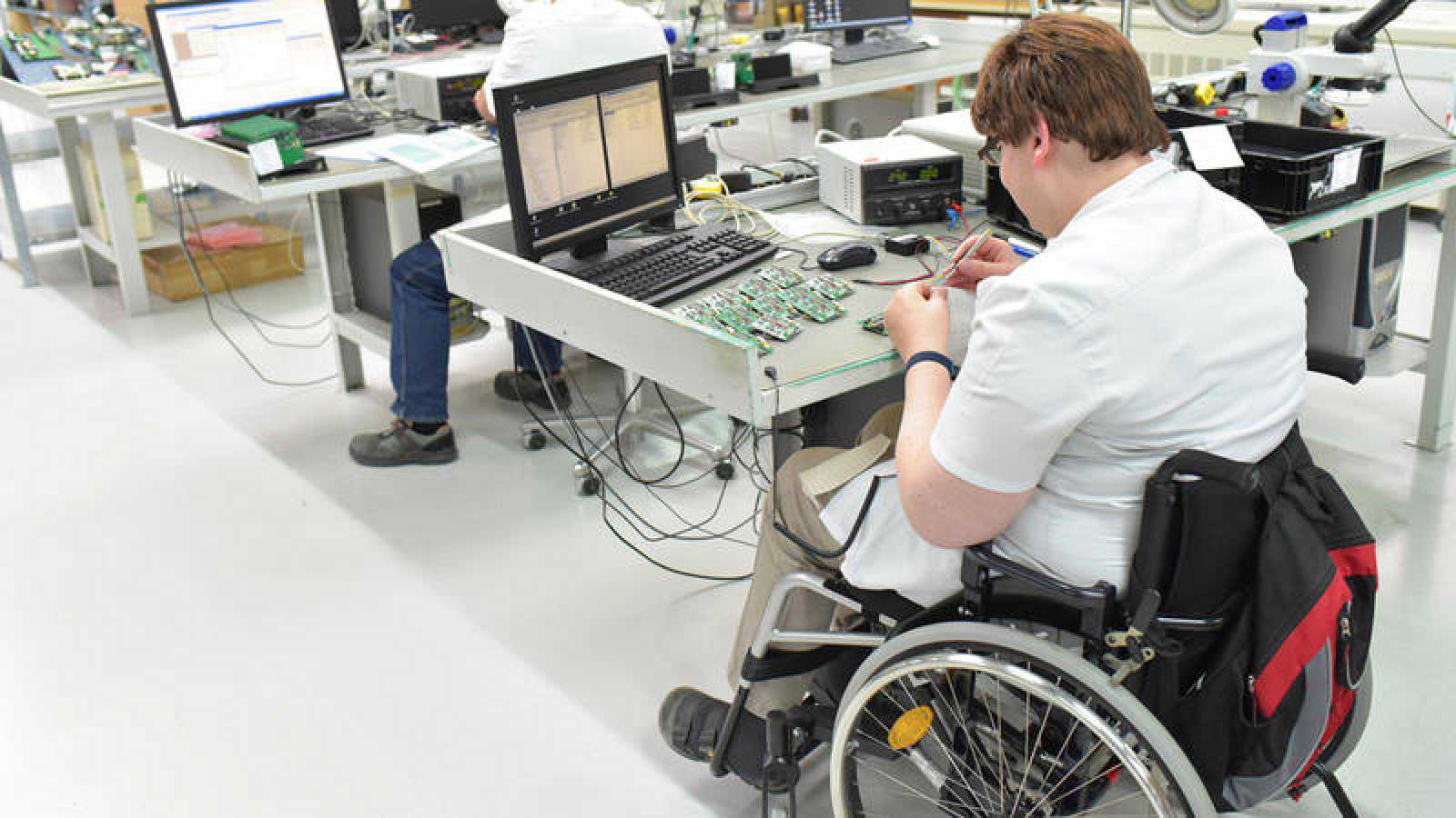 Discapacitado trabajando en una fábrica de ensamblaje de componentes electrónicos.