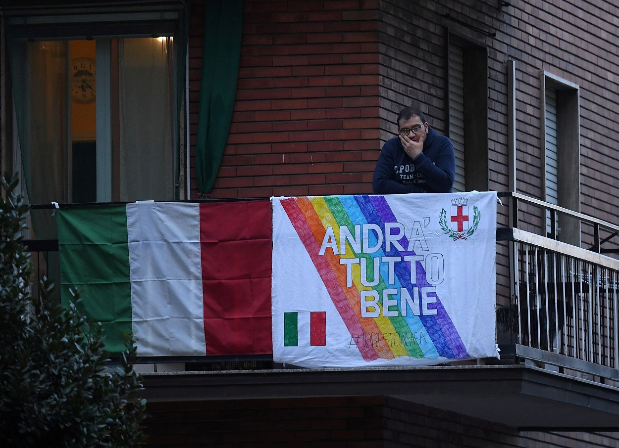 Un hombre, en el balcón de su vivienda en Roma, con una pancarta con el lema " Andra Tutto Bene" ("Todo va a ir bien"). REUTERS/Daniele Mascolo