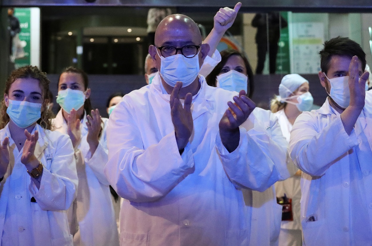 Personal sanitario de un hospital de Barcelona responde a los aplausos de los ciudadanos en agradecimiento por su trabajo en la crisis del coronavirus. REUTERS/Nacho Doce