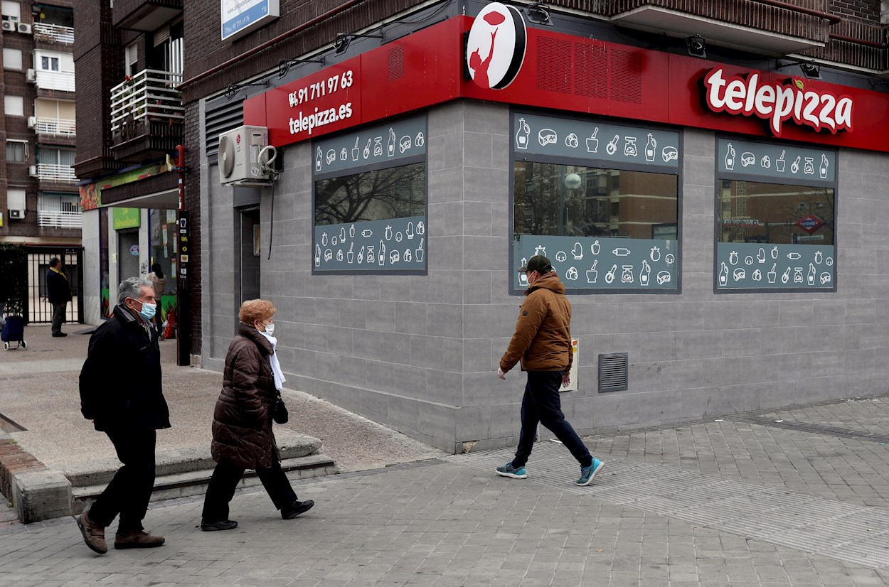 Peatones con mascarilla pasan frente a un restaurante Telepizza en Madrid. EFE/ Kiko Huesca
