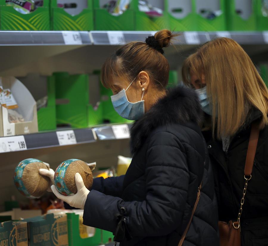 Dos mujeres con mascarilla y guantes se abastecen en un supermercado en Bilbao. EFE/LUIS TEJIDO