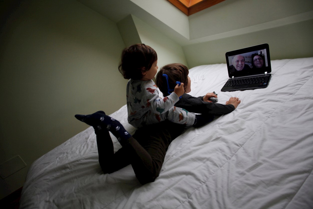 Dos niños conversan con sus abuelos mediante una videollamada en su casa. EFE/Cabalar