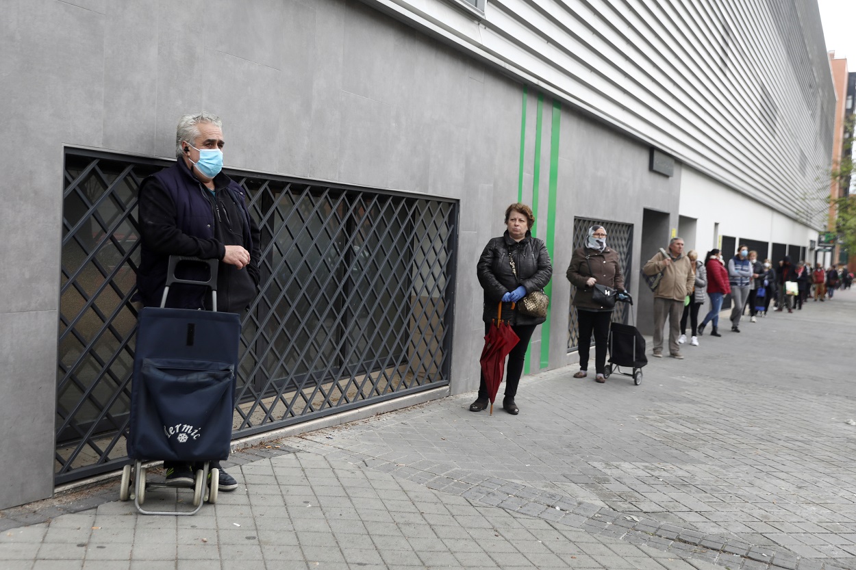 Varias personas hacen cola manteniendo la distancia social, esperando a entrar en un supermercado en Madrid. REUTERS/Sergio Perez