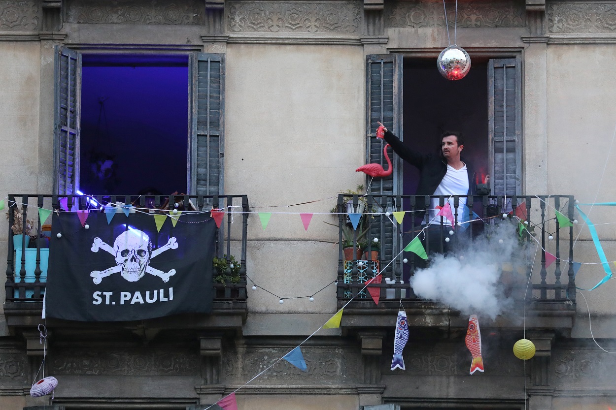 Un joven, de fiesta en el balcón de su vivienda, durante el confinamiento decretado en el estado de alarma por la pandemia del coronavirus, en Barcelona. REUTERS/Nacho Doce