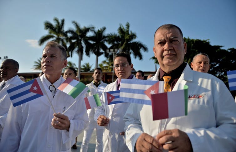 Médicos y enfermeras de la Brigada Médica Internacional Henry Reeve de Cuba se despiden antes de viajar a Italia para ayudar a combatir la pandemia de Covid-19. La Habana, 21 de marzo de 2020. Yamil Lage/AFP
