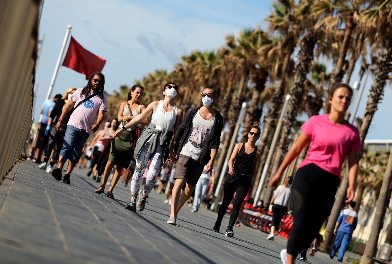 Personas paseando por la playa de la Barcelonetta, en el primer día que se permite paseos y actividades deportivas en la desescalada del estado de alarma por la pandemia de coronavirus. REUTERS/Nacho Doce