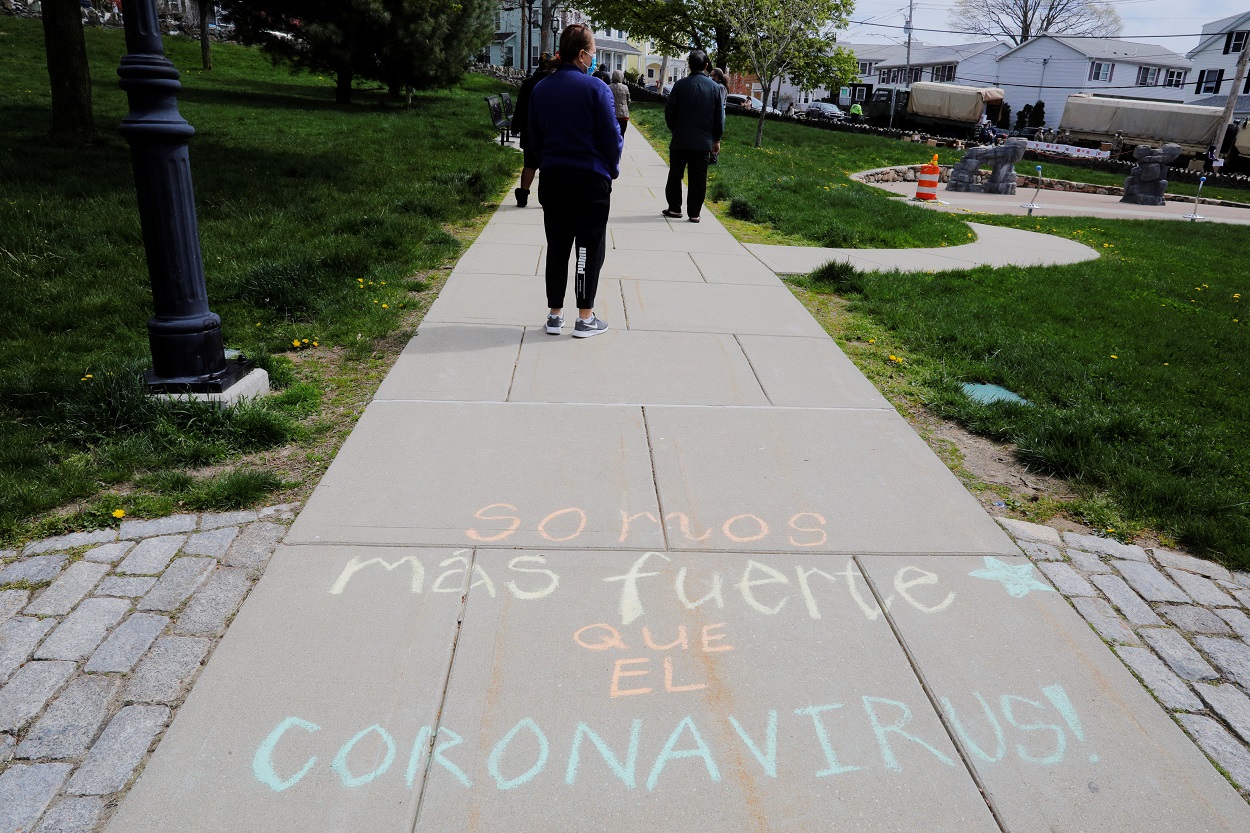 La frase "Somos Mas Fuerte Que El Coronavirus" pintada en una acera de la localidad estadounidense de Chelsea (Massachusetts). REUTERS/Brian Snyder