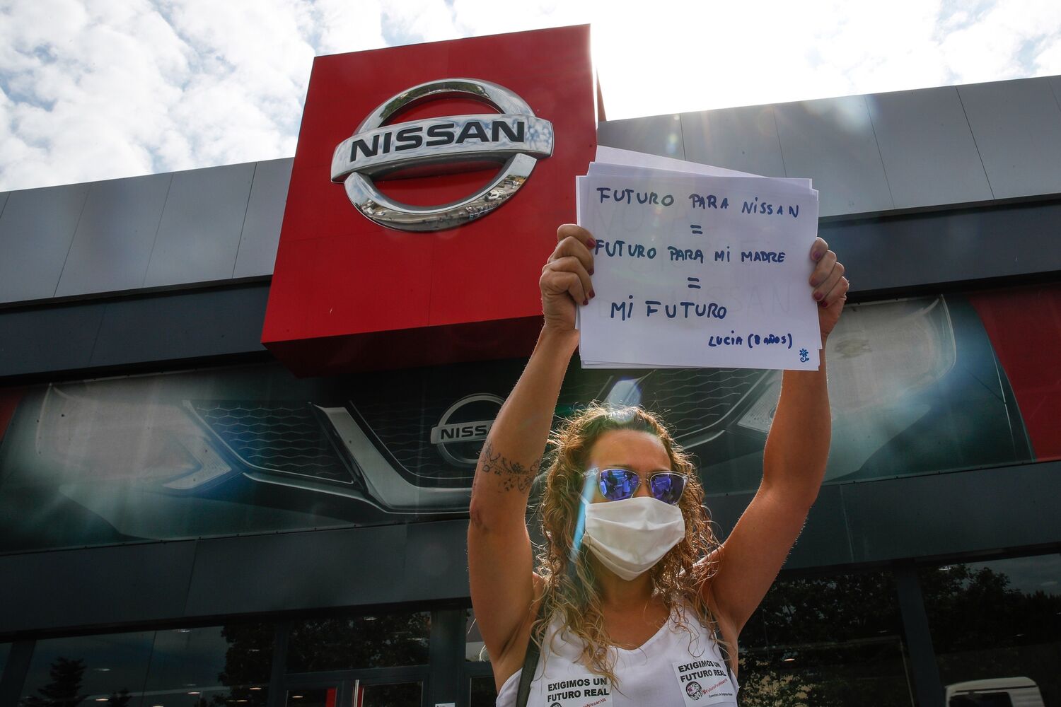 Una trabajadora de Nissan protesta por el anunciado cierre de la planta de la Zona Franca de Barcelona, frente a un concesionario de la firma japonesa en Granollers. EFE/Alejandro Garcia