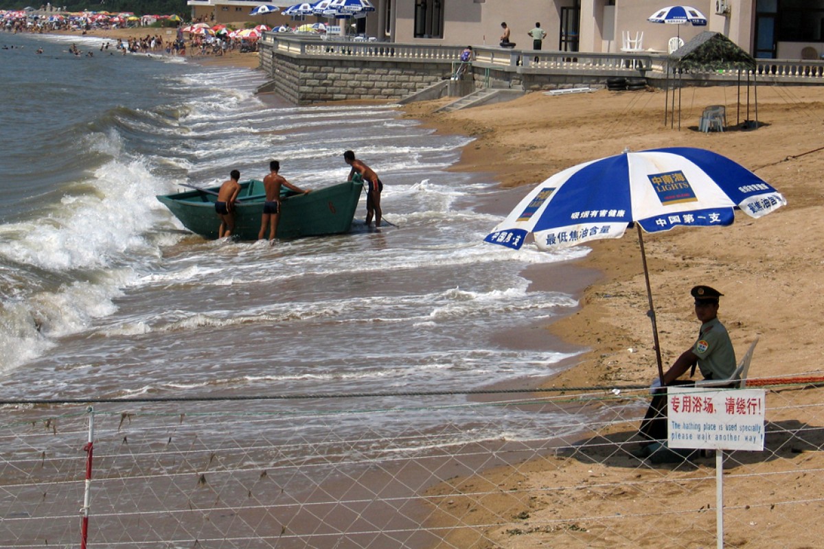 Un agente vigila la zona de la playa de la localidad costera china de Beidaihe reservada para los funcionarios del Gobierno. REUTERS