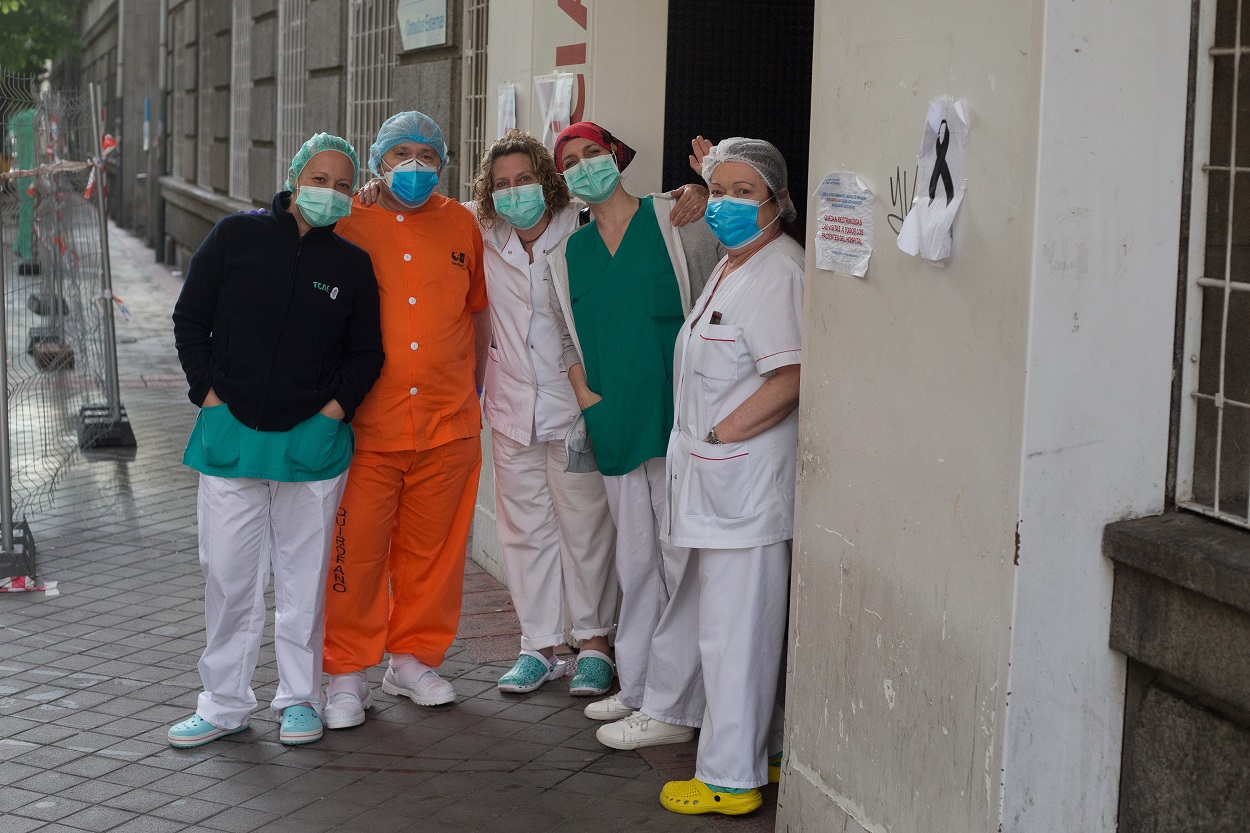 Un grupo de sanitarios posa para la foto junto a un lazo de luto por los fallecidos por coronavirus en el Hospital de la Princesa durante la pandemia de Covid-19. E.P./Joaquin Corchero
