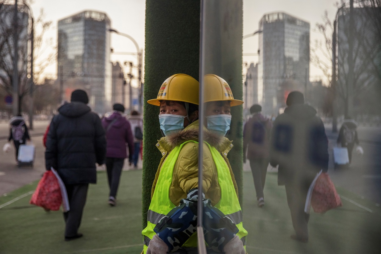 Un trabajador con mascarilla, en el exterior de un edificio en construcción en Pekín (China). REUTERS/Thomas Peter