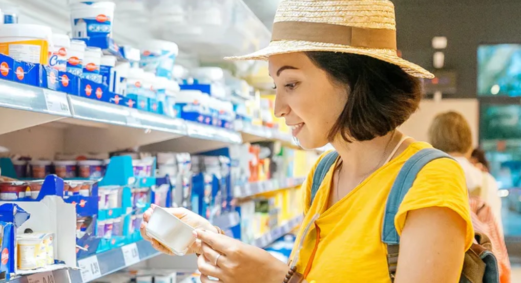Mujer observa un recipiente en un supermercado