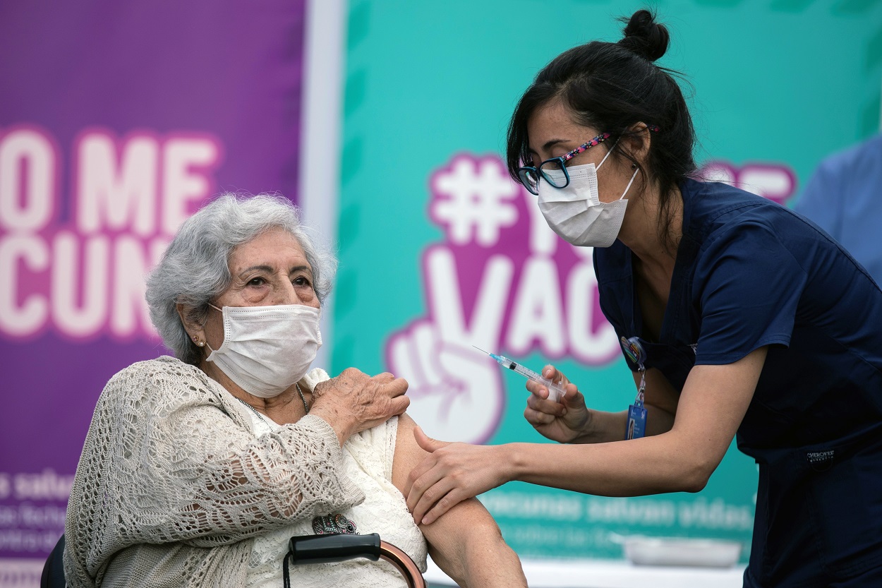 Una enfermera vacuna a una mujer en Chile. EPA-EFE