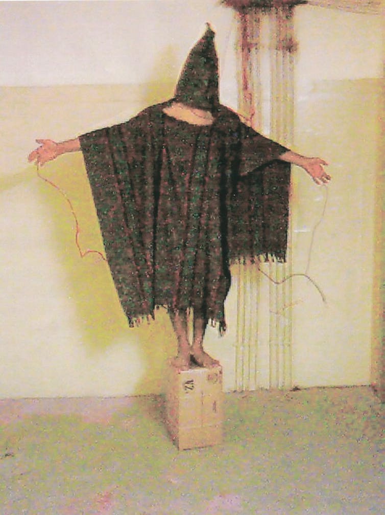 El prisionero de la prisión de Abu Ghraib (Irak) Abdou Hussain Saad Faleh (Gilligan), siendo torturado con cables electrificados conectados a sus manos y genitales. Fotografía tomada el 4 de noviembre de 2003