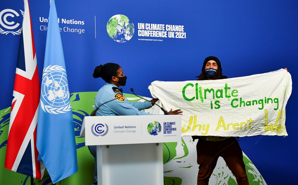 Un hombre interrumpe una rueda de prensa de la COP26. REUTERS/Dylan Martinez