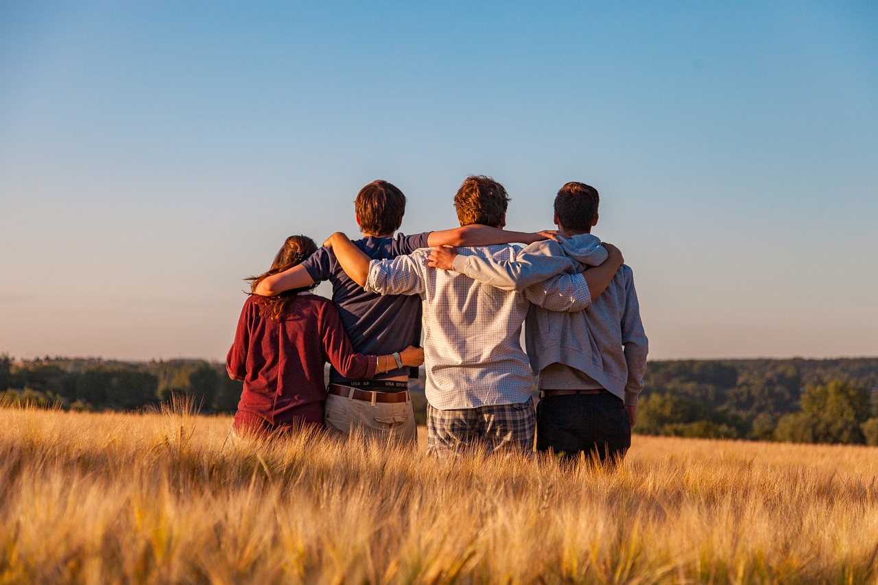 Un grupo de amigos abrazados en el campo.-DIM HOU / Pixabay